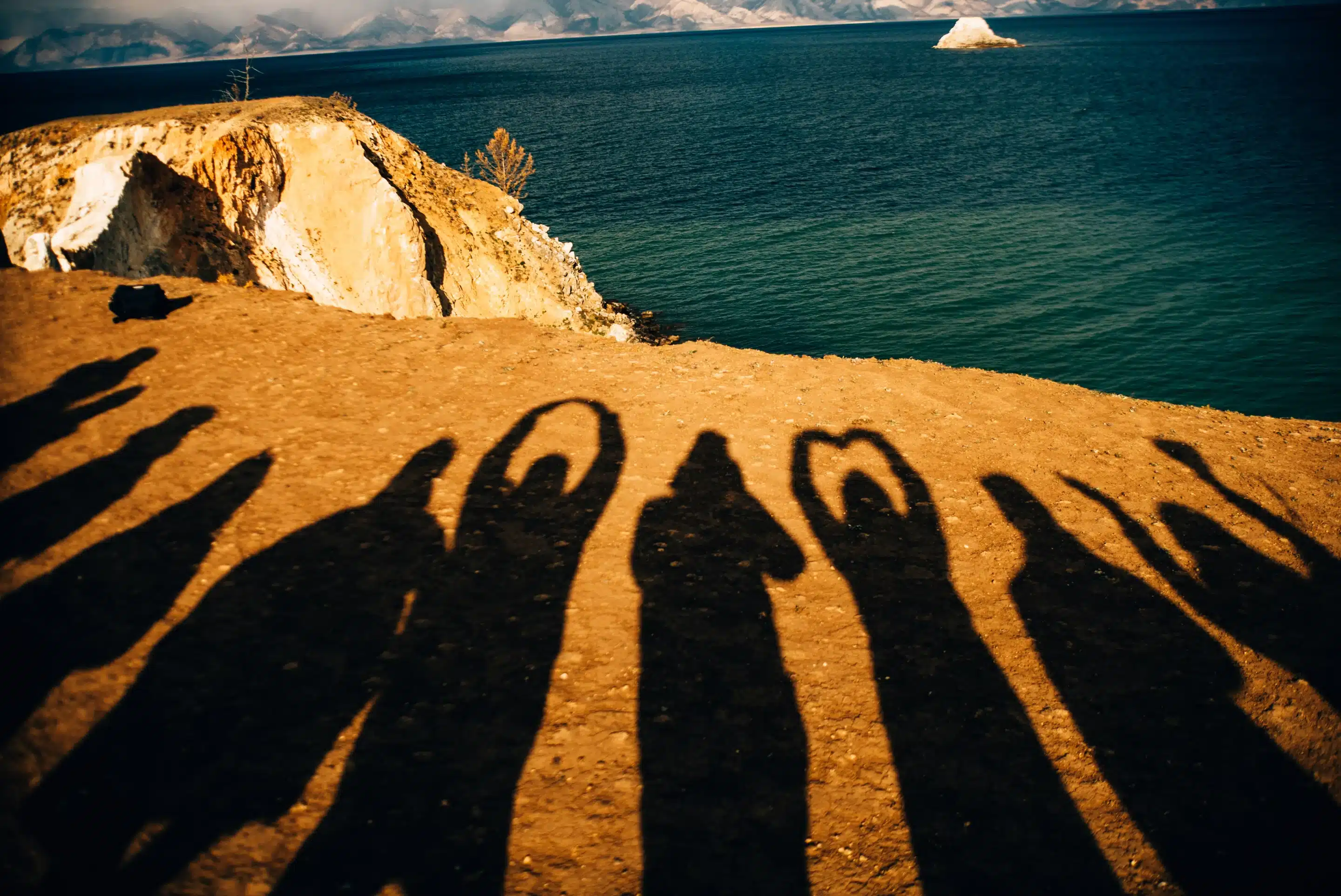 Shadows of people holding up hand hearts